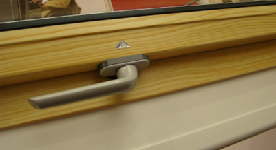 Multifunkční klika na rámu plastového střešního okna Roto v dekoru Borovice