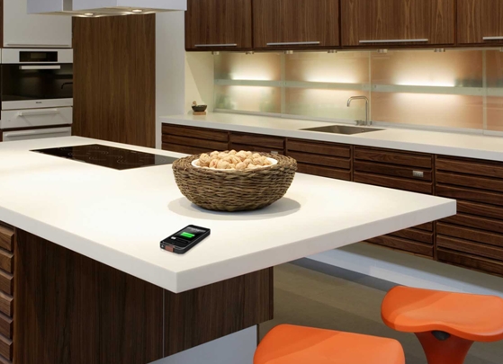 Vizualizace nového bezdrátového napájecího systému PMA kompatibilního s Duracell Powermat pro iPhone 5, který se dobíjí na pracovní kuchyňské desce z DuPont™ Corian®. Foto DuPont™ Corian® / PMA