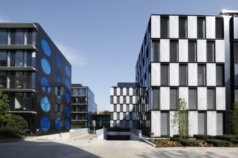 Fasády objektů B.O.C. i T.O.C. jsou charakteristické geometrickými tvary. Černobílý šachovnicový vzor objektu B.O.C. kontrastuje s metalickými černomodrými kruhovými obrazci sousedícího objektu T.O.C. Foto www.rehfeld-fotografie.de.