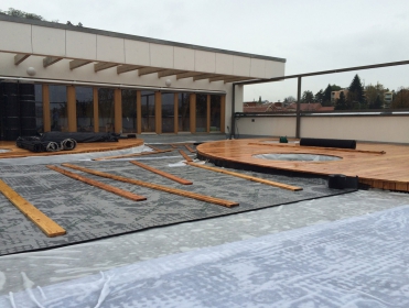 Provizorní zatížení vodou, která okamžitě vyplní nopy (7 l/m²), a prkny proti účinkům větru