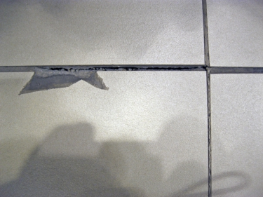 Obr. 3: Čím menší velikosti dlaždic, tím větší je počet dlaždic a spár, které přicházejí do styku s dráhou koleček. Obrázek ukazuje příklad „poškozených dlaždic“ a „vypadlé“ malty ze spár.