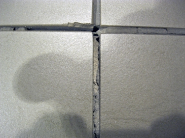 Obr. 3: Čím menší velikosti dlaždic, tím větší je počet dlaždic a spár, které přicházejí do styku s dráhou koleček. Obrázek ukazuje příklad „poškozených dlaždic“ a „vypadlé“ malty ze spár.