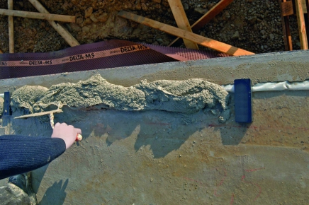 Příprava dilatačních podložek a nanesení výplňové malty po obvodu stavby. Do tohoto maltového lože se pak vloží obvodová stěna a do podkladu se upevní kotvami.