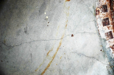 Obr. 3: Trhliny v základové desce vycházející od poklopu kanalizační šachty 