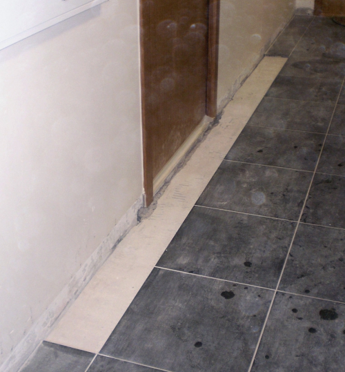 Obr. 4: Vstupní dveře do bytu, odstraněná nášlapná vrstva a oddělená roznášecí vrstva