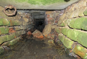Obr. 9: Rozpad zdiva a kumulace vody v odvodňovacím kanálu