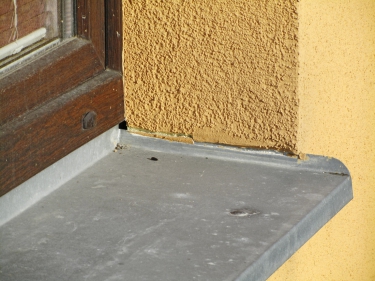 Obr. 1–4: Chybné napojení okenního rámu nebo parapetu (bez napojovacích lišt a těsnicích pásek) na stěnu či zateplovací systém – vliverm teplotní dilatace rámu nebo parapetu brzy dochází ke vzniku trhlin a následnému zatékání do konstrukce