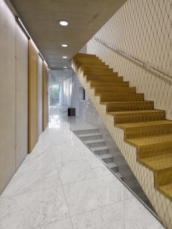 Schodiště má v nadzemních podlažích místo zábradlí asymetricky kotvenou nerezovou síť