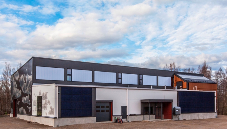 Pohled na jižní trakt budovy – velká okna, na pravé a levé straně panely On-Wall solar, nad pravým polem panelů je vidět obklad ze samopatinujících fasádních panelů Cor-Ten