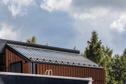 Část budovy s fasádou ze samopatinující oceli Cor-Ten. Šikmá střecha je z krytiny Ruukki Classic s plně integrovaným solárním systémem pro ohřev vody (Ruukki Classic Solar).