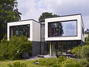 Projekt rodinného domu vychází z požadavku klienta prostory co nejvíce otevřít směrem k jezeru. Nerušený výhled zprostředkovávají úzké okenní a fasádní profily Schüco.