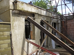 Obr. 13: Zemním tlakem poškozená čelní stěna stavby v patě svahu