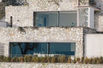 Novou a původní zástavbu sbližuje podobná velikost i použité materiály. U novostavby byl na dvou podlažích instalován velkoformátový posuvný systém Schüco s automatizovaným ovládáním, alarmem i externím zastíněním; foto Andrea Puliogotto
