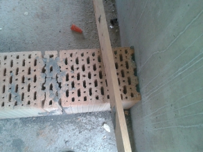 Obr. 28: Chybné napojení na navazující monolitickou konstrukci na sucho (vzniklé mezery tvoří akustický most), na této fotce také nepřípustné řešení v místě spáry u řezu cihelného bloku