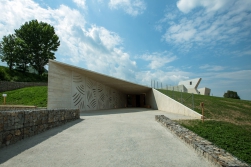 Prakticky celý výstavní prostor je skrytý v terénní vlně. Do výšky se tyčí pouze věže, kterými se do podzemí dostává světlo