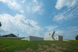 Prakticky celý výstavní prostor je skrytý v terénní vlně. Do výšky se tyčí pouze věže, kterými se do podzemí dostává světlo