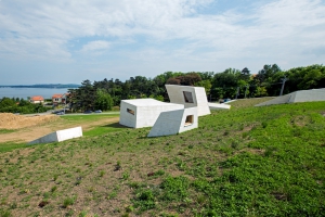 Prakticky celý výstavní prostor je skrytý v terénní vlně. Do výšky se tyčí pouze věže, kterými se do podzemí dostává světlo