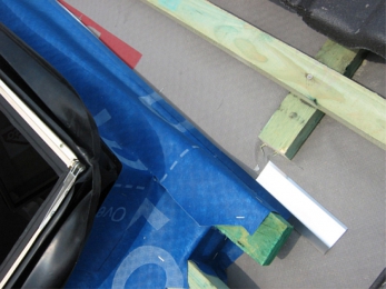 Obr. 13: Montážní límec vytvořený z pruhů paropropustné fólie s možností dodatečného zateplení – pohled na horní roh před přelepením odváděcího žlábku nad oknem