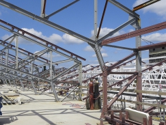 Zvýšená konstrukce střechy na centrální budově – zvednutá příhradová podpěra, v pozadí stávající podpěry