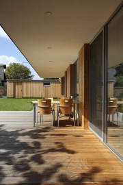 Terasa u hlavního obytného prostoru, vzadu malá dřevěná stavba, která slouží jako sklad