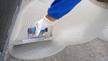 Nalitá stěrka se následně upravuje zubovým hladítkem