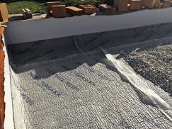 Integrované lepení v podélném okraji plošně drenážních pásů DELTA-TERRAXX zajišťuje jejich stabilitu při pokládce a brání pronikání kačírku