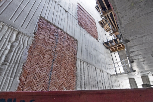 „Okna“ v bednění vyplněná starými cihlami nalezenými na stavbě