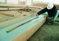 Obr. 7c: Pohled na štíhlou konstrukci haly, zjevně nevyhovující tenké stykové desky, zcela nadměrně zvlněné stěny nosníků celkově chybná výroba