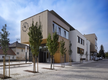 Obě poloviny komplexu školy jsou propojeny velkou střechou, která sjednocuje menší části kompozice ve větší celek a přináší tak budově razantnější měřítko