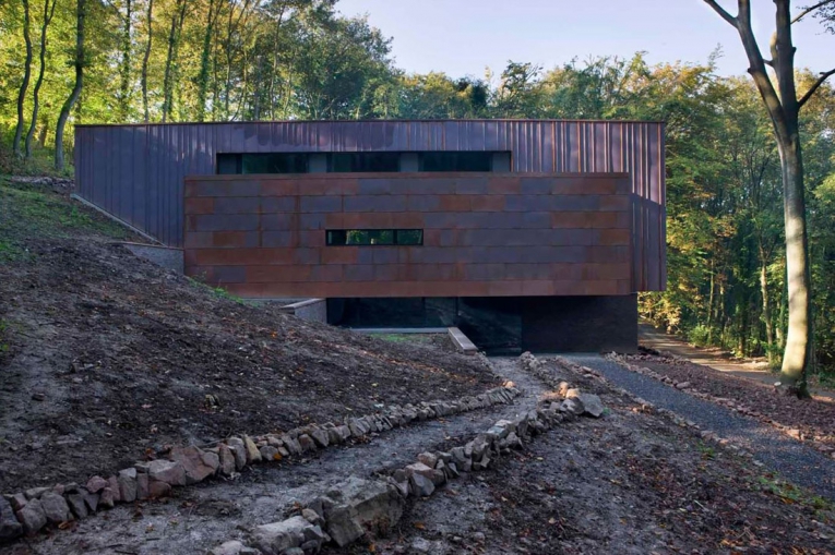 Obr. 3: Fasáda na vstupní (severní) straně upoutá pozornost tříúrovňovým uspořádáním. Na spodní cihlovou část (suterén) navazuje "plachta či křídlo" vyčnívající z prvního podlaží.