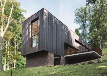 Obr. 4: Budova je strukturovaná kolmo ke svahu a fyzikálně i opticky zasazena do terénu. Fasádní panely z mědi charakterizuje přirozená matně hnědá patina.