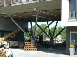 Obr. 16a: Mohutná hmota budovy podepřená zcela chybně ocelovými čtyřnožkami s jednosměrnými klouby a nevhodnými čepy