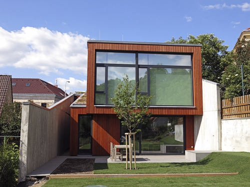 Difuzně otevřená dřevostavba je vestavěná do úžiny betonových stěn