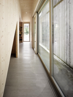 Průchod v sousedství pohledové betonové stěny