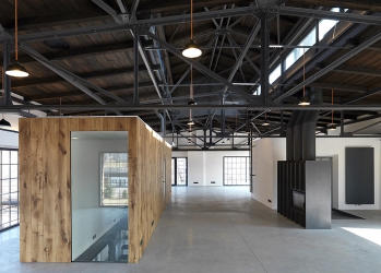 Zázemí pro jednotlivá podlaží, jako toalety, kuchyňky nebo úklidová místnost, jsou záměrně volně situovány do prostoru vložených boxů