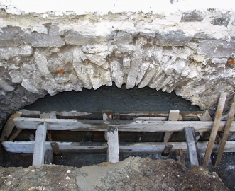 Obr. 1: Neočekávané středověké uspořádání kamenných klenbových základů pod uliční zdí městského domu.