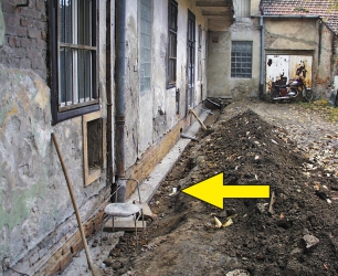 Obr. 10: Přibetonování základů zvenčí domu (šipka)
