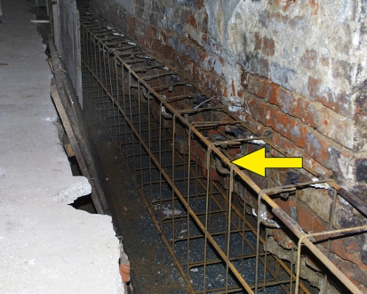 Obr. 12: Podélná a příčná výztuž zesílení (rozšíření) základového pásu s kotvením mikrohřeby (šipka)