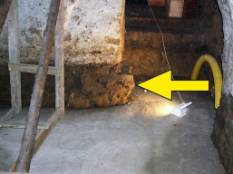 Obr. 22: Sklepní pilíř (bez základu) před započetím statického zajištění (šipka).