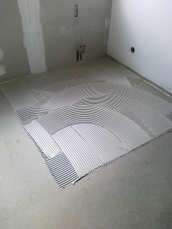 Nanesení lepidla na podklad (např. Ceresit CM 16, CM 17, CM 22, CM 92, CM 77)