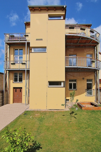 Jednoduchou dvorní fasádu bylo možné ztvárnit současným způsobem. Jsou u ní nové terasy a balkony, na izolaci z minerální vlny je tradiční jádrová omítka.