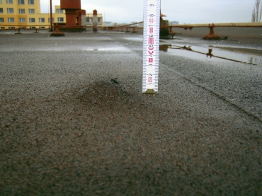 Nevhodné kotvení se uvolňuje, protrhává hydroizolační asfaltový pás. Na vině je použití fasádních hmoždinek, které nepatří na plochou střechu.