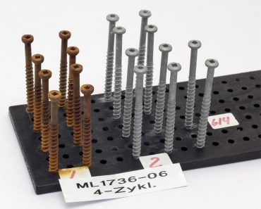 Zkouška korozní odolnosti kotev (Kesternichův test). Vpravo kvalitní šrouby pro kotvení plochých střech do betonového podkladu, vlevo jejich napodobenina odkudsi z Asie, postrádající vrstvu proti korozi. Stav po 4, resp. 10, zatěžovacích cyklech v agresivní atmosféře. Kotva by měla vydržet bez známky koroze alespoň 12 cyklů.