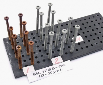 Zkouška korozní odolnosti kotev (Kesternichův test). Vpravo kvalitní šrouby pro kotvení plochých střech do betonového podkladu, vlevo jejich napodobenina odkudsi z Asie, postrádající vrstvu proti korozi. Stav po 4, resp. 10, zatěžovacích cyklech v agresivní atmosféře. Kotva by měla vydržet bez známky koroze alespoň 12 cyklů.