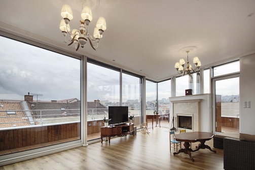 Na jižním konci je obývací pokoj s panoramatickým francouzským oknem s výhledem na město