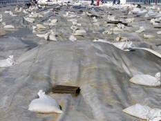 Obr. 5: Havárie plochých střech v důsledku námahy větrem – selhání kotvení okraje střechy bylo první fází selhání celé střechy