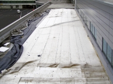 Obr. 6: Havárie plochých střech v důsledku námahy větrem – selhání kotvení okraje střechy bylo první fází selhání celé střechy