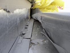 Obr. 14: Detail kotvení fólie u paty světlíku – při náporu větru sice vydrželo kotvení vlastního koutového profilu, fólie se ale odtrhla spolu s poplastovanou vrstvou