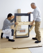 Přetočení křídla. Okno se opatrně vyjme z krabice a zvedne se do svislé polohy, což umožní přetočení křídla. Následně se postaví na horní část přetočeného křídla.