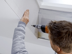 Ukotvení opláštění. Pomocí přímočaré nebo okružní pily se nařeže sádrokarton, který se pomocí vrutů ukotví do ocelového rámu vyplněného tepelnou izolací. Řezání a návrh sádrokartonového ostění ulehčuje montážní souprava.